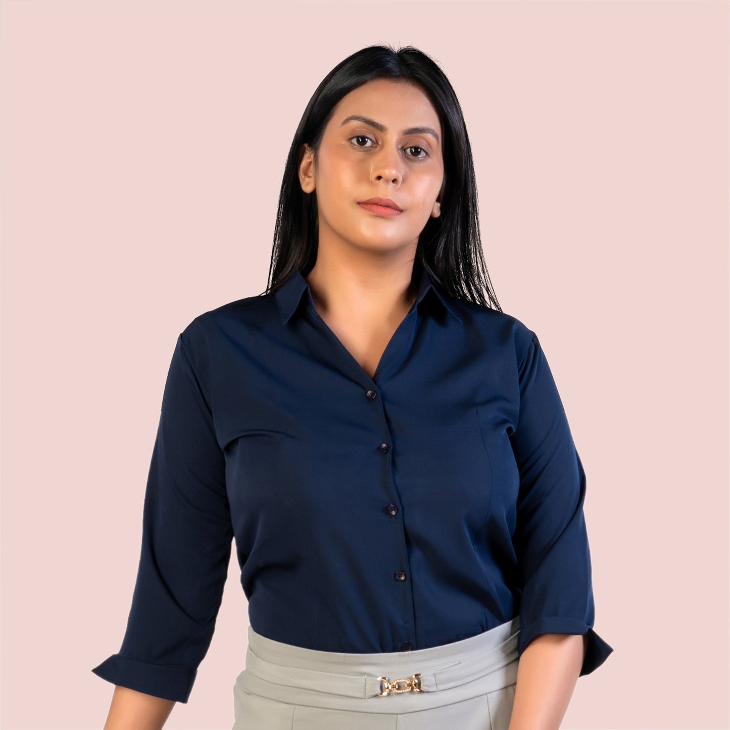 Woman wearing a navy blue shirt against a pink background