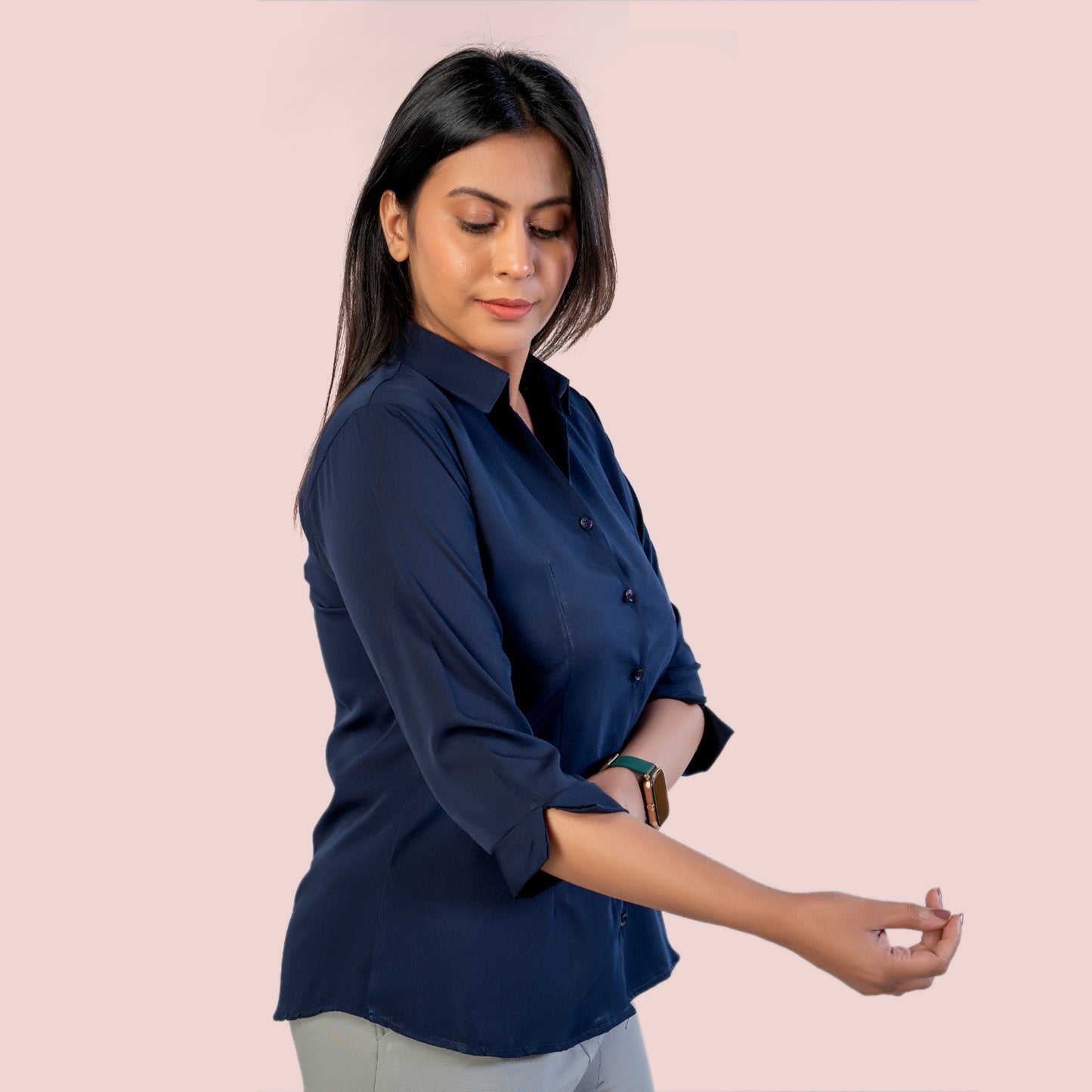 Woman wearing a navy blue shirt on a pink background